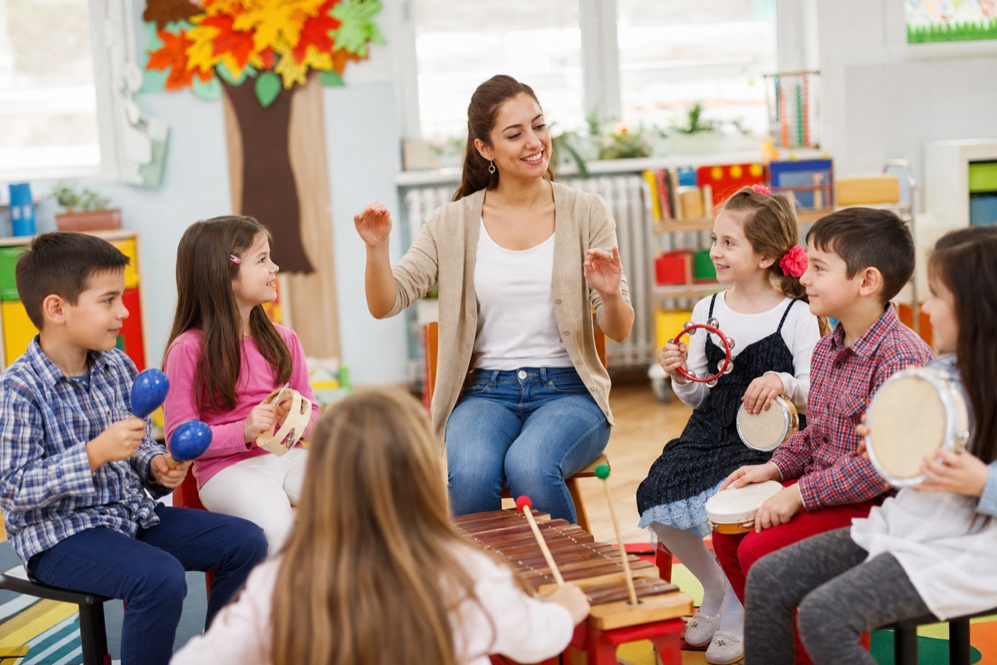 Copii cântând la instrumente muzicale în sala de clasă